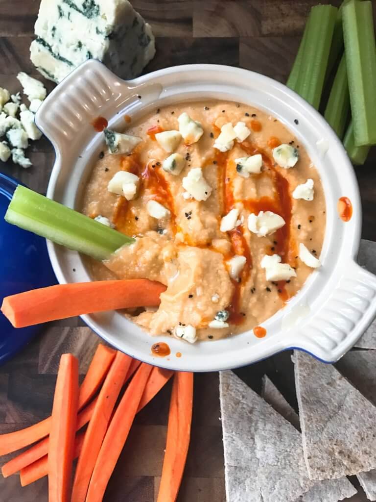 A bowl of Buffalo Wing Hummus with veggies in it