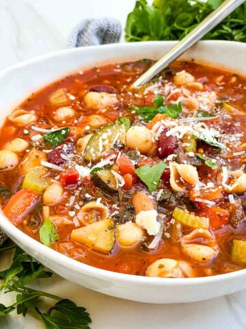 A bowl of Italian Minestrone Soup with a spoon in it.