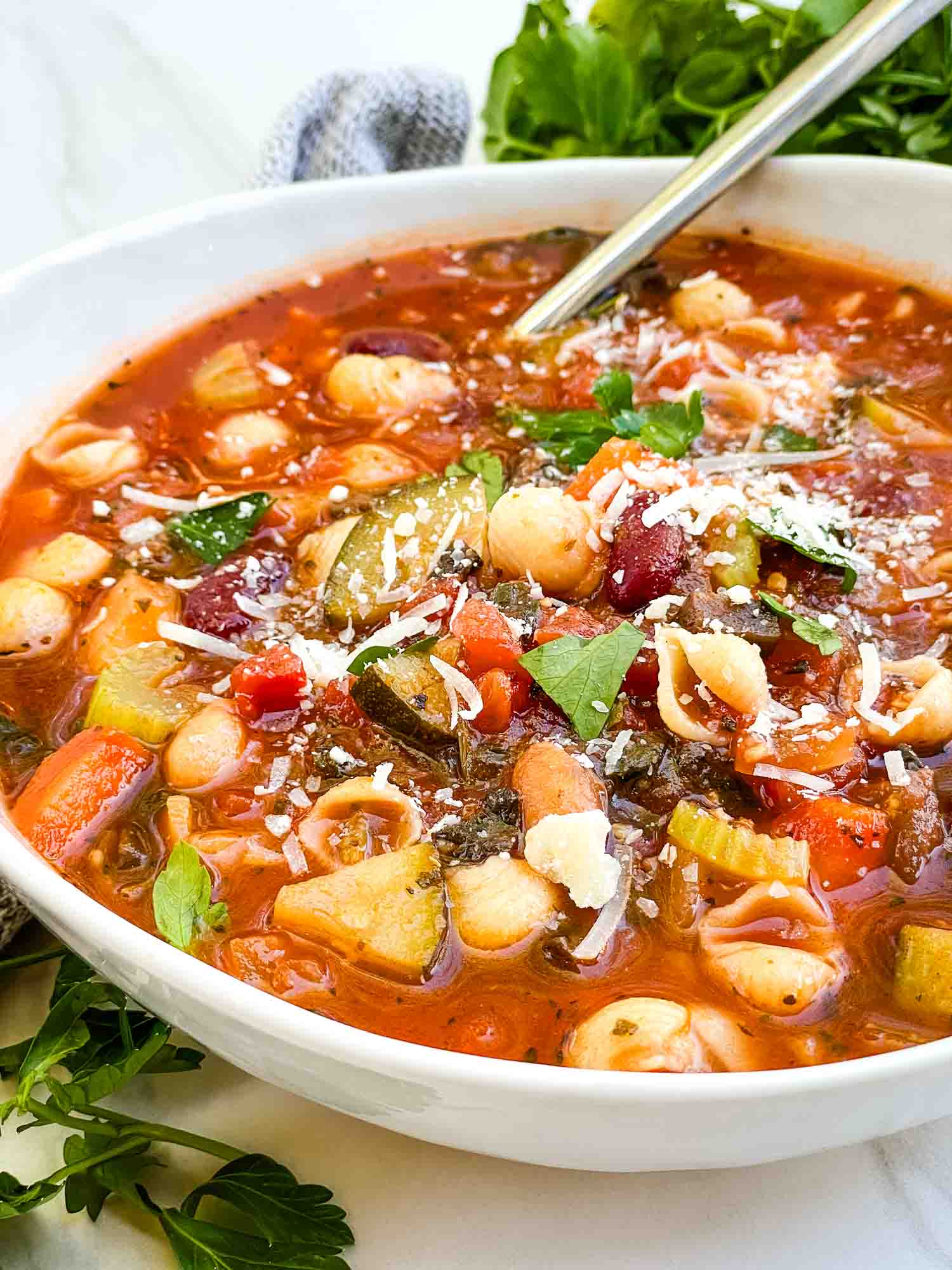 A bowl of Italian Minestrone Soup with a spoon in it.