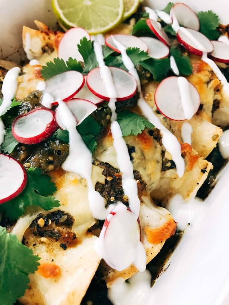 Close up of the food in a white dish with radishes and cilantro on top