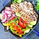 Citrus Chicken Fajitas on the Grill cut up and placed into a skillet with limes