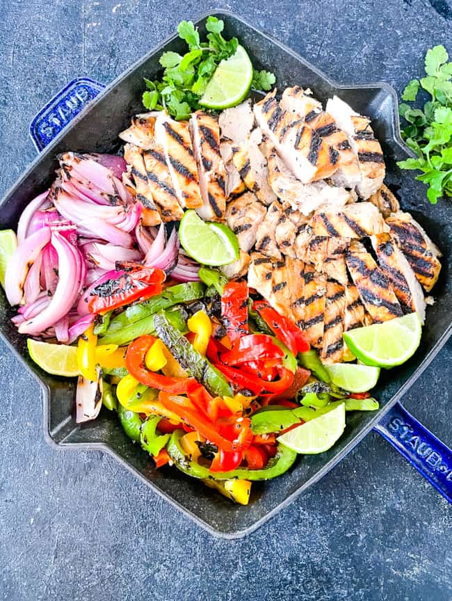 Citrus Chicken Fajitas on the Grill cut up and placed into a skillet with limes