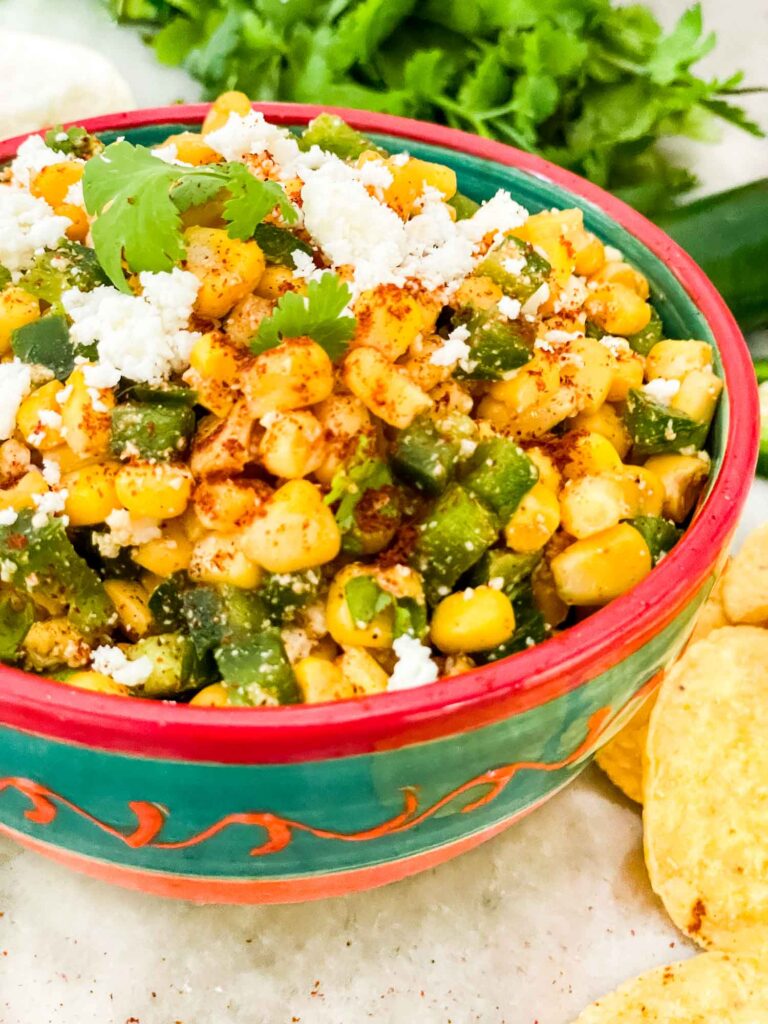 Mexican Street Corn Salsa (Esquites) in a Hispanic colored bowl on a counter