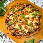 Caprese Pizza on a peel with drizzle balsamic vinegar