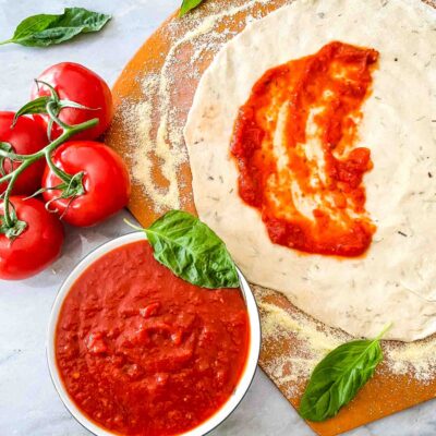 Homemade Pizza Sauce in a bowl next to pizza dough