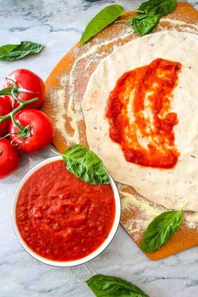 Homemade Pizza Sauce in a bowl next to pizza dough