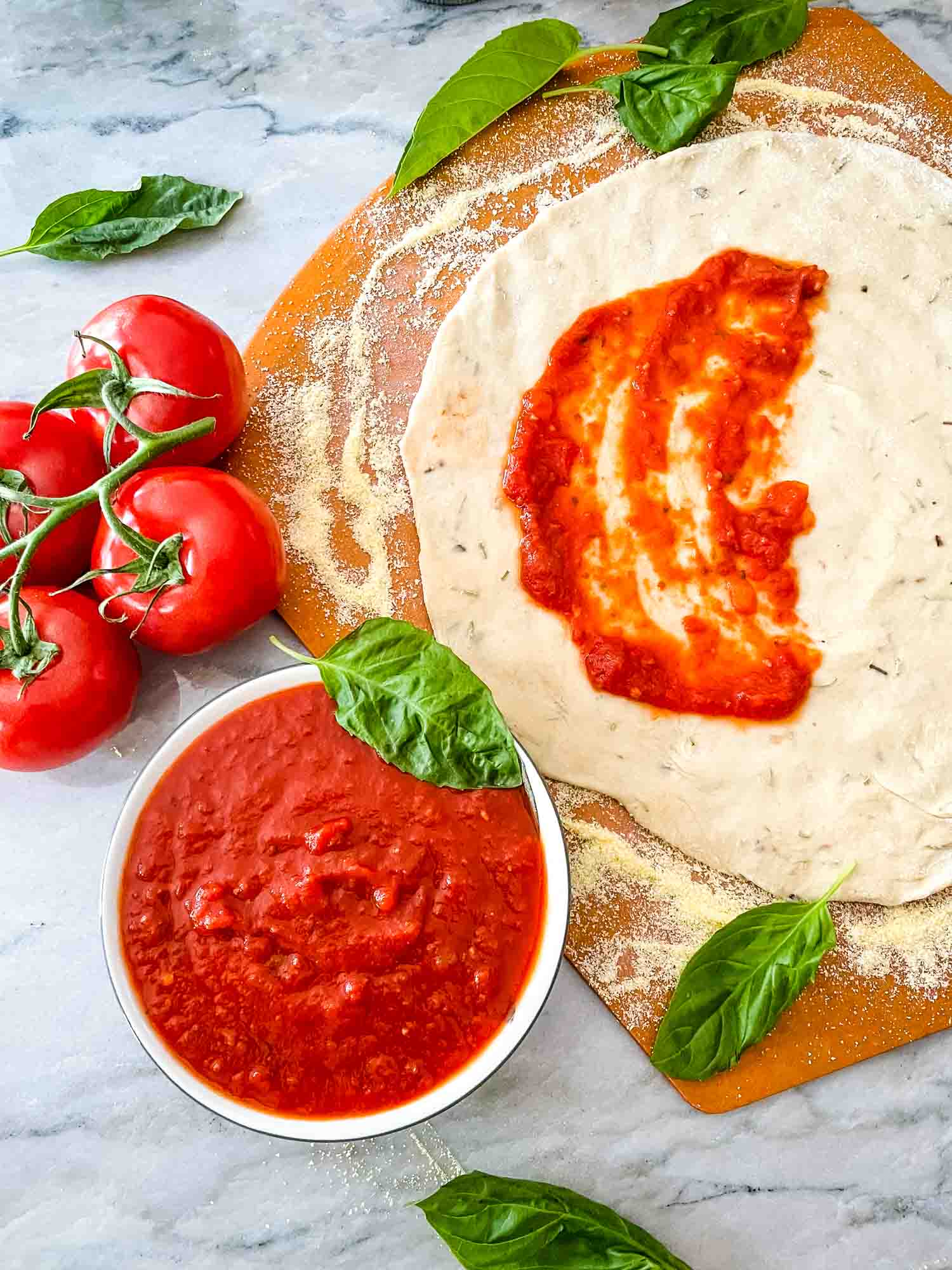 Homemade Pizza Sauce in a bowl next to pizza dough