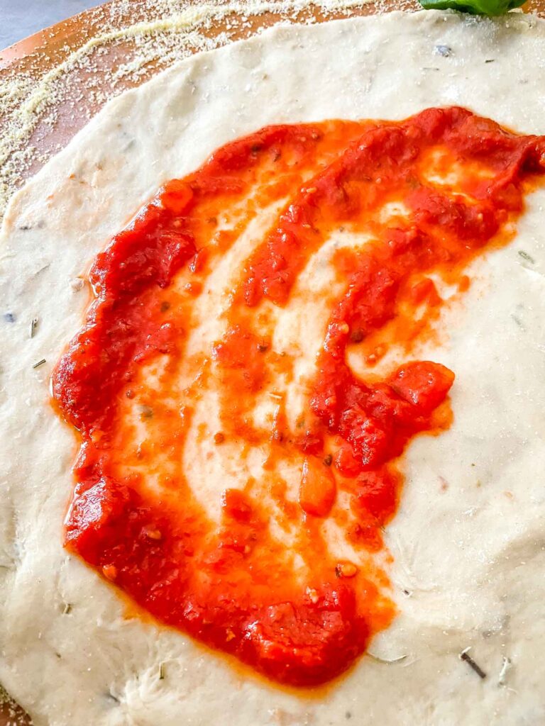 Homemade Pizza Sauce being spread across dough