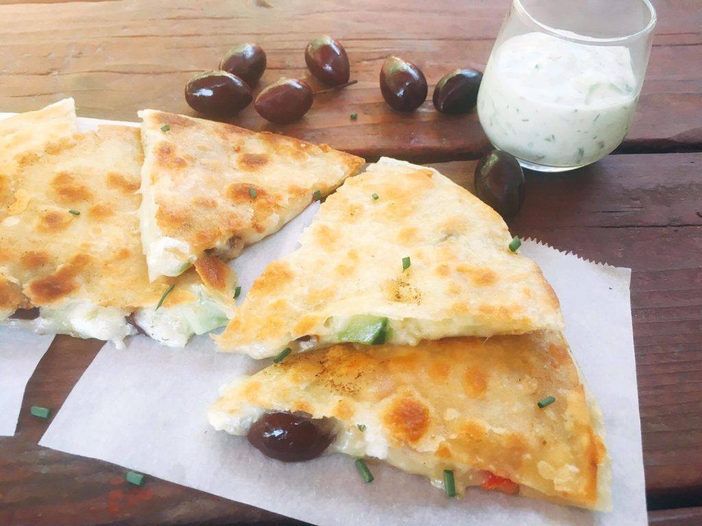 Ready in just 10 minutes! Greek Tzatziki Quesadilla is a great way to sneak some veggies into a fun snack or meal! All the flavors of Greek salad in quesadilla form with some tzatziki sauce inside for extra flavor and dipping. Vegetarian recipe | Three Olives Branch | www.threeolivesbranch.com