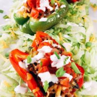 Beef Taco Stuffed Peppers sitting on a bed of shredded lettuce