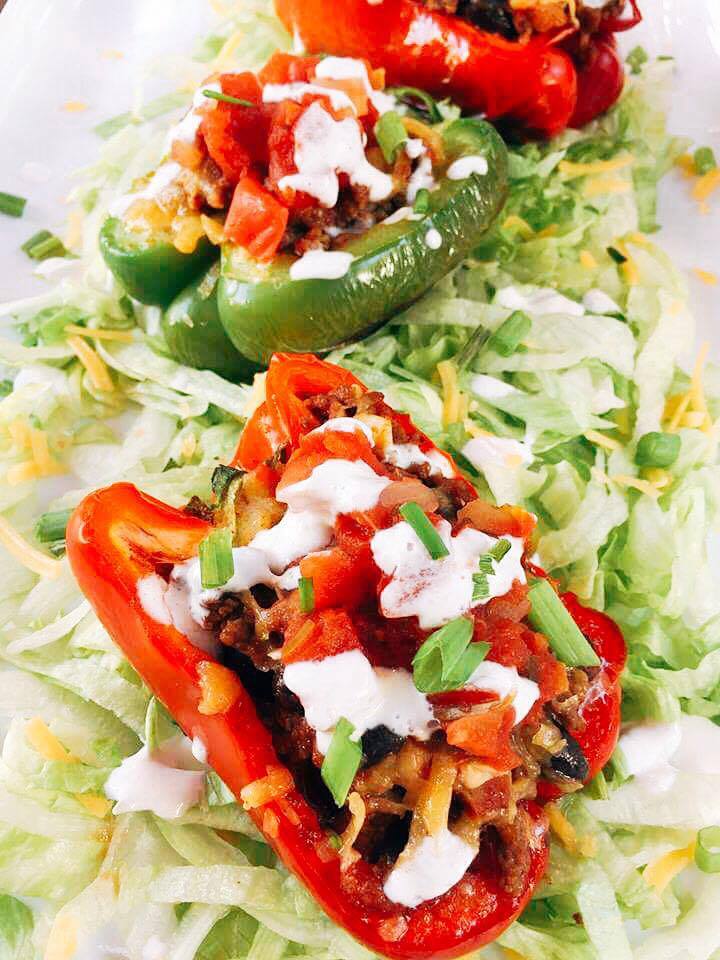 Beef Taco Stuffed Peppers sitting on a bed of shredded lettuce