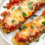 Two pieces of Three Cheese Zucchini Parmesan on a white plate