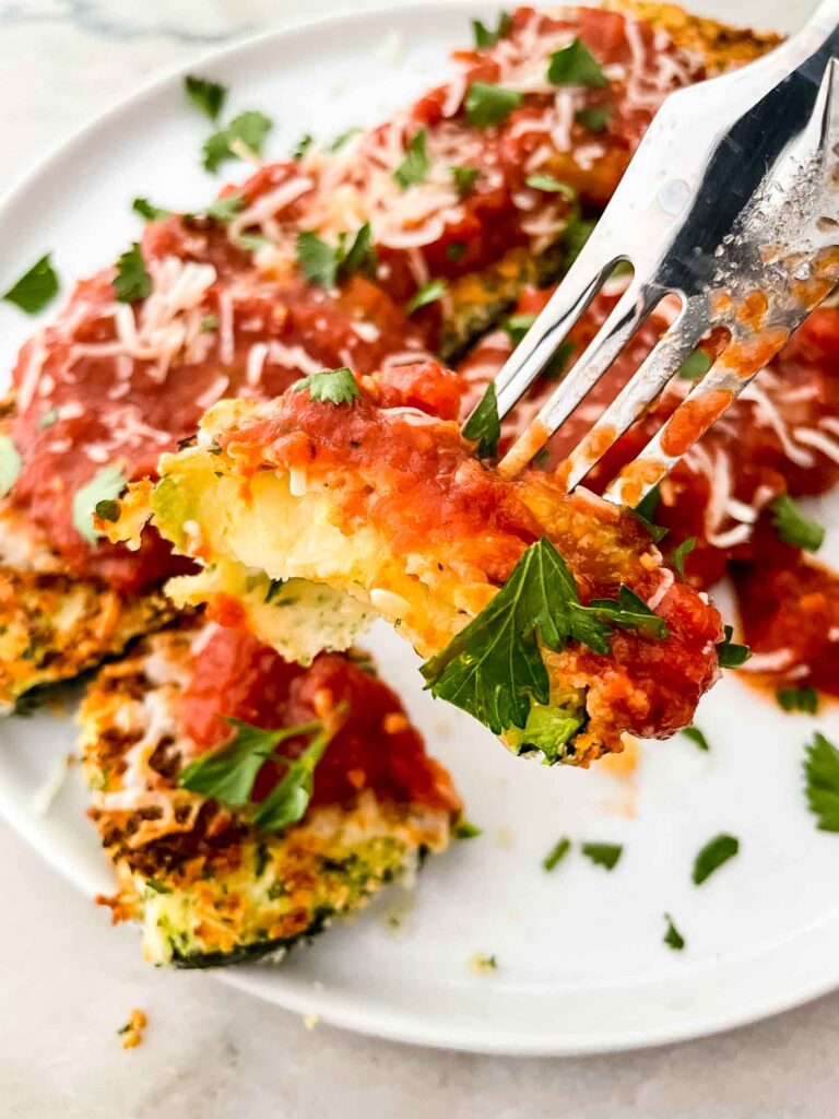 A fork lifting a piece of Three Cheese Zucchini Parmesan