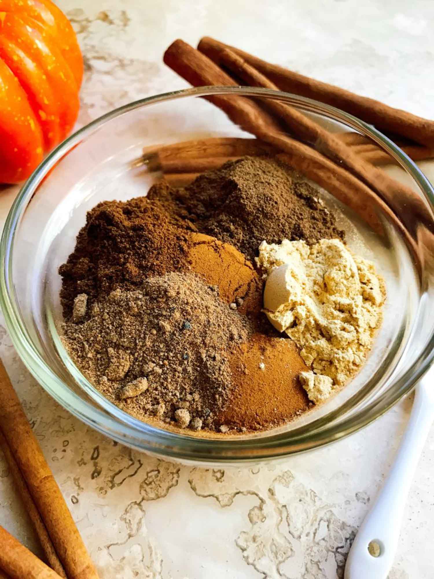 The spices all piled into a small clear bowl on a counter