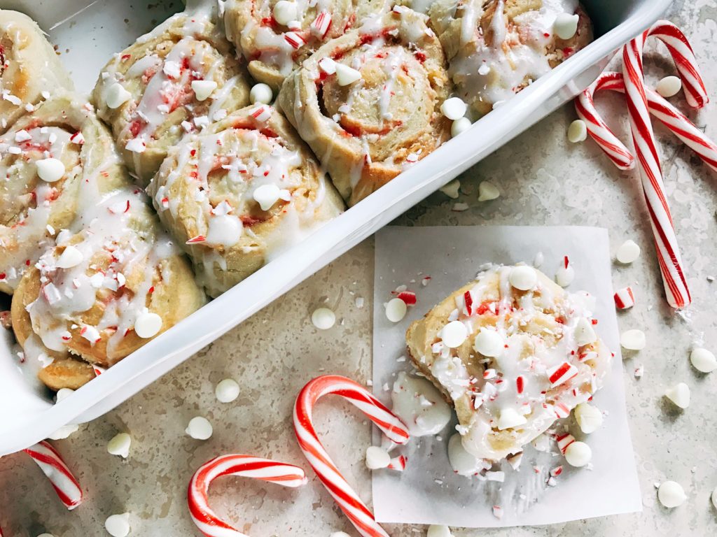 Top view of a tray of the rolls with one removed and some candy canes