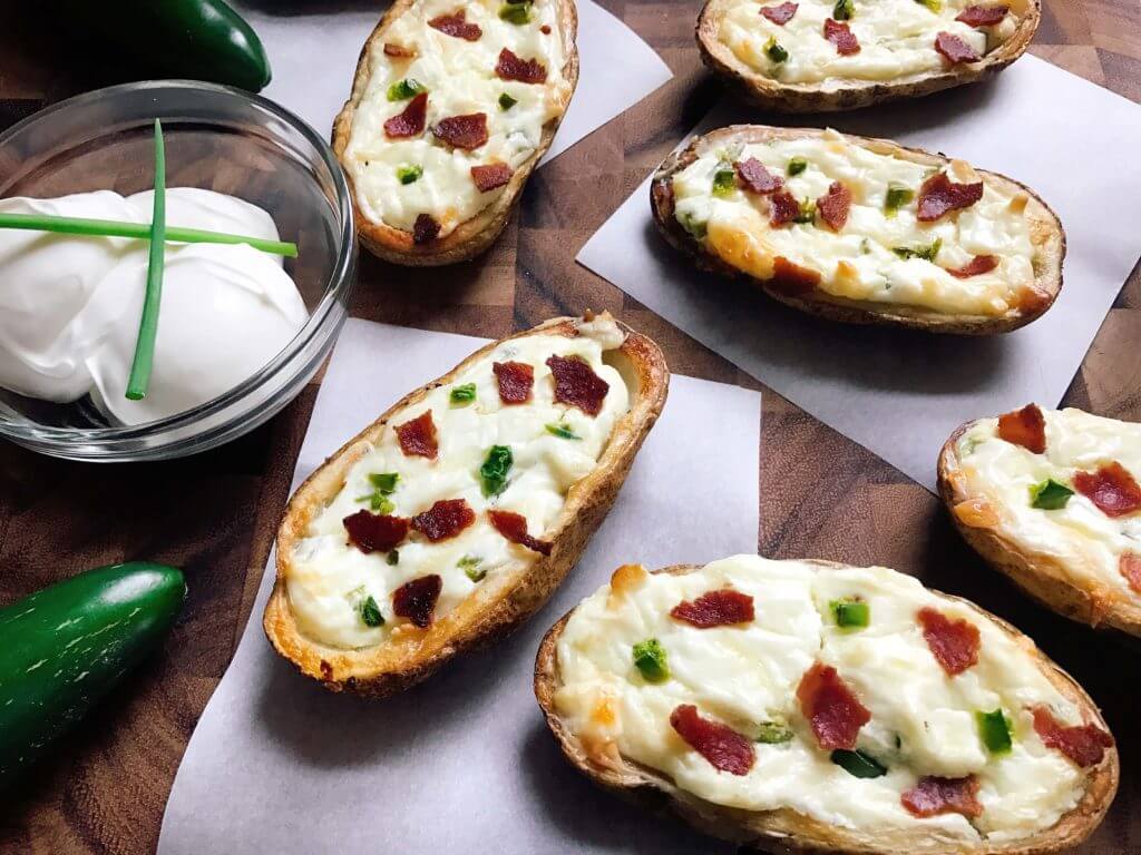 Perfect for the big game, these Jalapeno Popper Potato Skins are one of our favorites! Control the spicy heat level with the amount of jalapeno you use and this is perfect as an appetizer, especially for football games! Easy to make and vegetarian friendly. Three Olives Branch | www.threeolivesbranch.com 