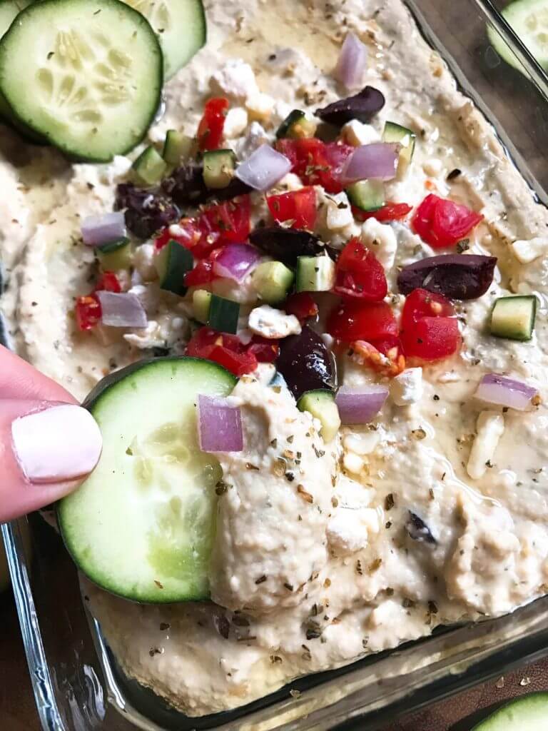 Less than 5 minutes to make this delicious and healthy hummus! Perfect as an appetizer, snack, or spread, the flavors of tzatziki and Greek salad are bright and fresh. Full of protein, vegetarian and vegan friendly. Perfect for game day! Greek Tzatziki Hummus | Three Olives Branch | www.threeolivesbranch.com