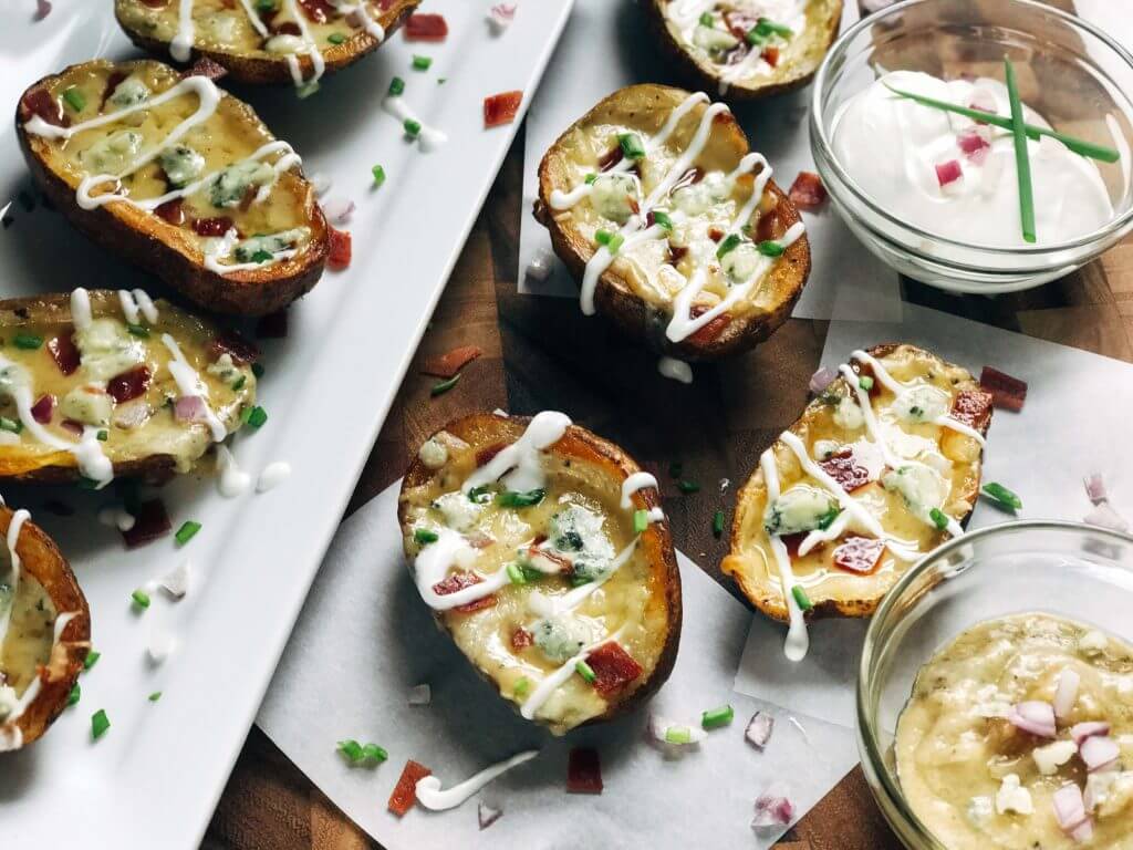 Potato skins on a plate and board with dipping sauces