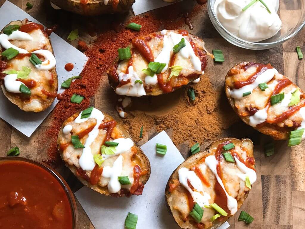 Make each component in advance for fast assembly! All the flavors of smoky chipotle enchiladas in potato skin form. Make your sauce mild or spicy. Perfect for game day as an appetizer or snack! Great football food as they are portable and full of flavor. Smoky Chicken Enchilada Potato Skins | Three Olives Branch | www.threeolivesbranch.com