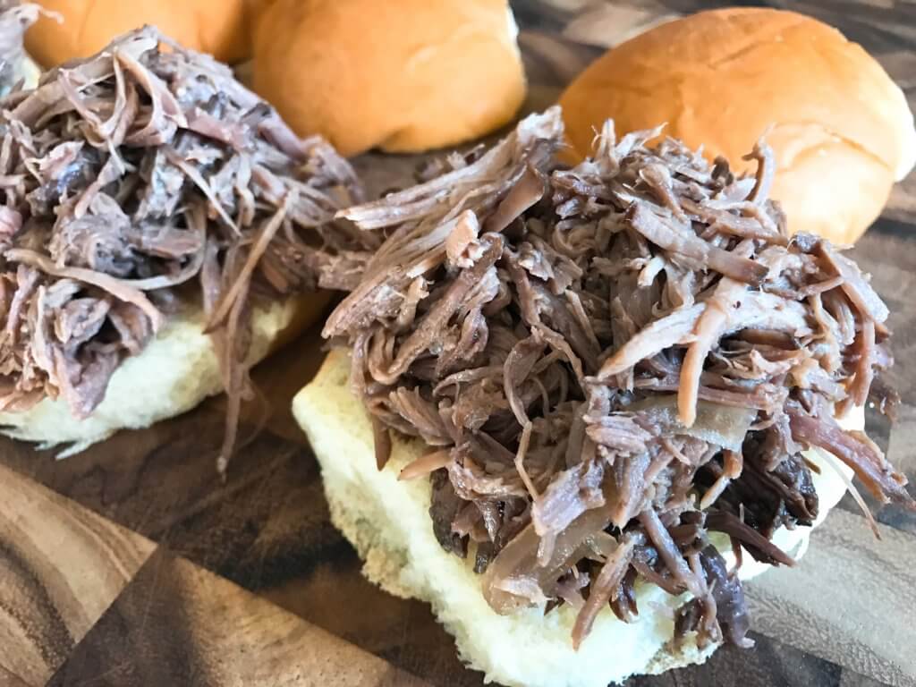 Use a slow cooker for simple and easy shredded steak sliders! Make the blue cheese sauce in advance for quick assembly. Perfect for your party, homegating, football or sport event like Super Bowl Sunday! Make them into a slider bar for customization. Kind friendly and lots of topping options like bacon, pickles, pepperoncini, and more! Bourbon Blue Cheese Steak Sliders | Three Olives Branch | www.threeolivesbranch.com