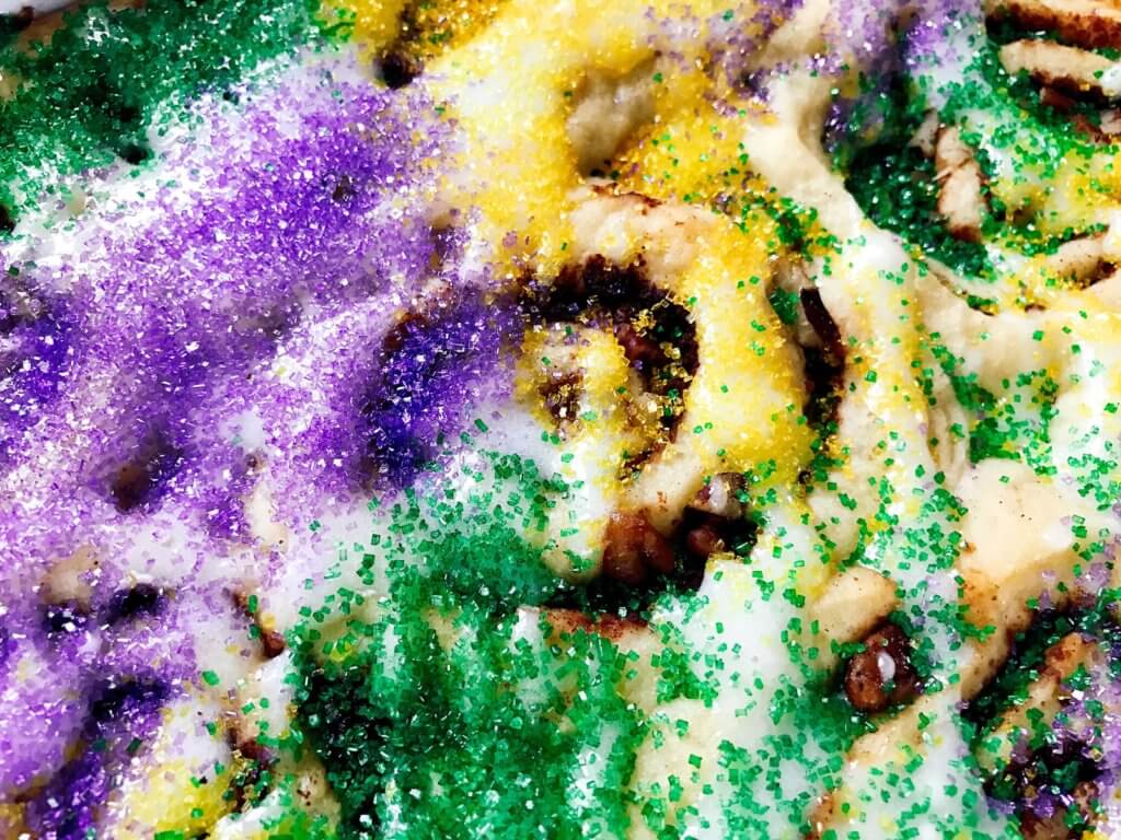 Make in advance for an easy breakfast! Comfort food perfect for the holiday. Vegetarian and kid friendly. Pecan, cinnamon, and flaky dough. Mardi Gras King Cake Cinnamon Rolls | Three Olives Branch | www.threeolivesbranch.com