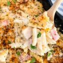 A spoon digging into a Chicken Cordon Bleu Casserole dish