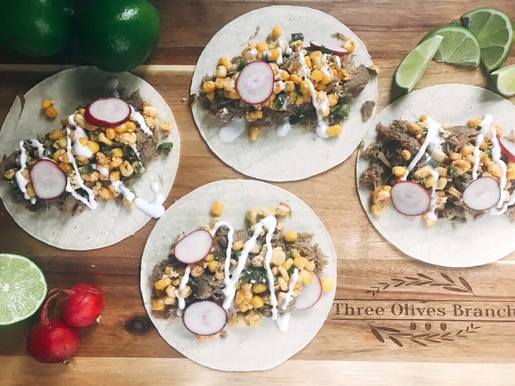 Less than 30 minutes for these fast and simple tacos! Easy to make and perfect for leftovers. Fresh corn salsa pairs perfectly with the seasoned pork. Pork Carnitas Mexican Street Corn Tacos | Three Olives Branch | www.threeolivesbranch.com