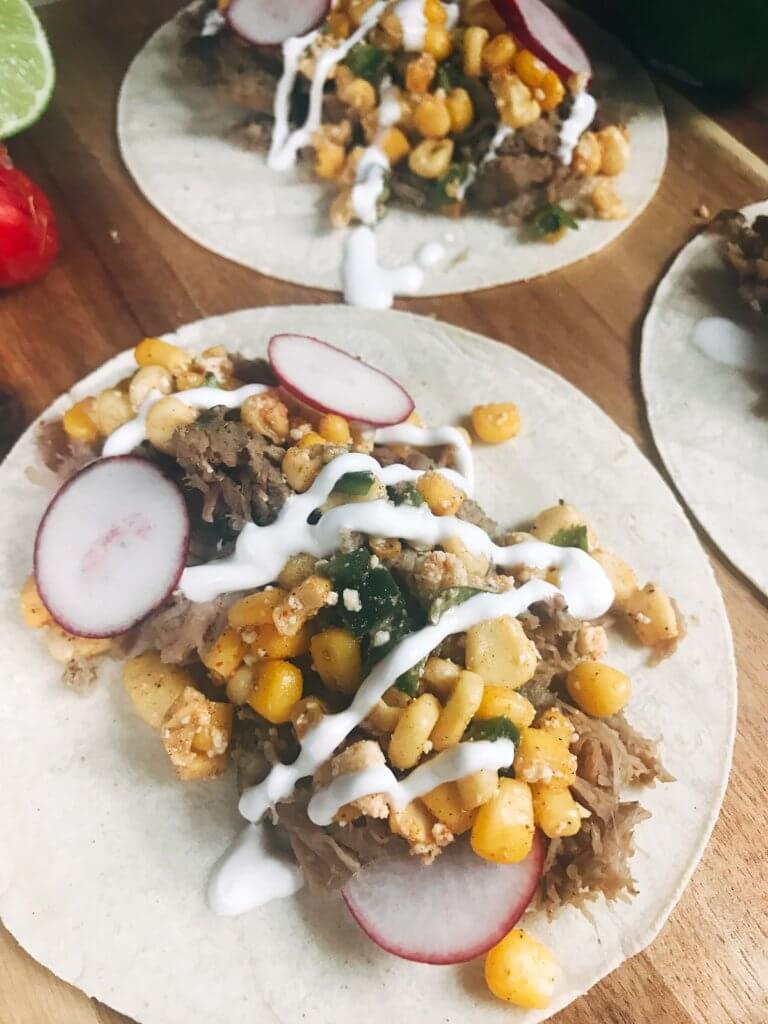 Less than 30 minutes for these fast and simple tacos! Easy to make and perfect for leftovers. Fresh corn salsa pairs perfectly with the seasoned pork. Pork Carnitas Mexican Street Corn Tacos | Three Olives Branch | www.threeolivesbranch.com