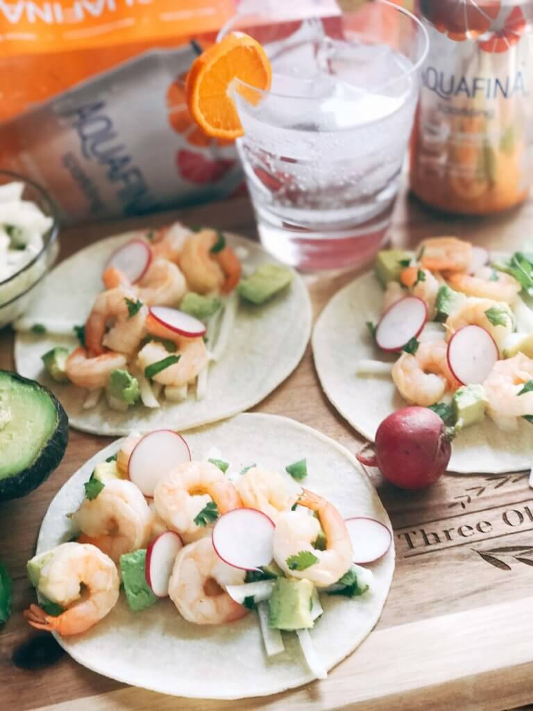 Less than 30 minutes for these simple and fresh shrimp tacos. Perfect for on-the-go food, full of bright and fresh flavors. Shrimp, orange, grapefruit, avocado, and jicama inspired by Aquafina Sparkling Water. A great twist on a seafood taco for Mexican night. Quick and easy to make, perfect for summer. Grapefruit Orange Shrimp Tacos with Jicama Slaw | Three Olives Branch | www.threeolivesbranch.com