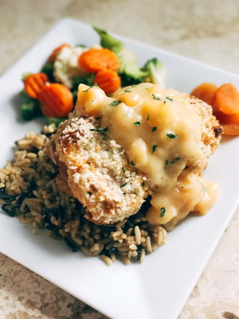 A slightly sweet twist on the classic! Dried apricots pair perfectly with the ham, monterey jack cheese, and seasonings in this recipe revamp. The creamy apricot white wine sauce is the perfect addition! A fun and memorable dinner that the entire family will love. Apricot Chicken Cordon Bleu | Three Olives Branch | www.threeolivesbranch.com