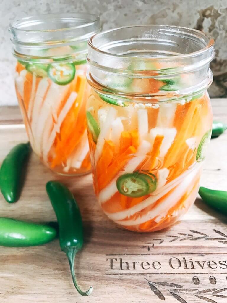 Simple and easy Spicy Vietnamese Pickled Vegetables perfect for your banh mi! Use as a quick condiment on your favorite foods. Quick refrigerator pickle of daikon radish and carrots are made spicy with serrano. A rice vinegar base is ready in just minutes for this classic Vietnamese slaw. Use cucumber or your favorite vegetables. Vegan, gluten free, and vegetarian. #pickled #banhmi #vietnamese