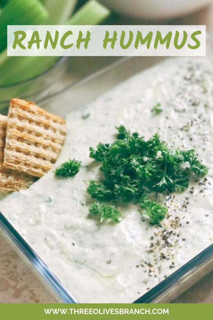 Pin of Ranch Hummus in a glass dish with fresh parsley on top and crackers. Title at top