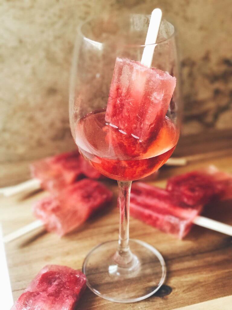 Popsicles made of rosé wine and raspberries! Simple to make and a great alcoholic adult treat for the warm and hot summer days. A twist on the frosé (frozé) trend, putting your favorite pink rose wine in popsicle form. A perfect treat or poptail for a cookout, barbecue, or grilling day. BBQ parties never tasted so good! Cocktail on a stick. Raspberry Rosé (Frosé) Popsicles | Three Olives Branch | www.threeolivesbranch.com