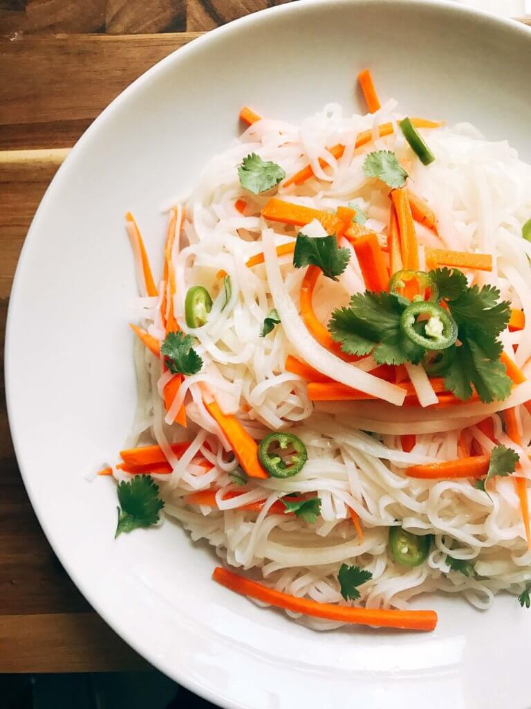 A simple and fast gluten free side dish that is perfect for summer grilling and entertaining. Vegan and vegetarian, this noodle salad is easy to make and a great fresh addition to a BBQ or party like the 4th of July or Father's Day. Add some tofu, chicken, or shrimp for a full dinner meal. Pickled carrots and daikon radish in a rice vinegar bright a fresh brightness and acidity. Make it spicy with some serrano or jalapeno. Vietnamese Pickled Vegetable Rice Noodle Salad | Three Olives Branch | www.threeolivesbranch.com