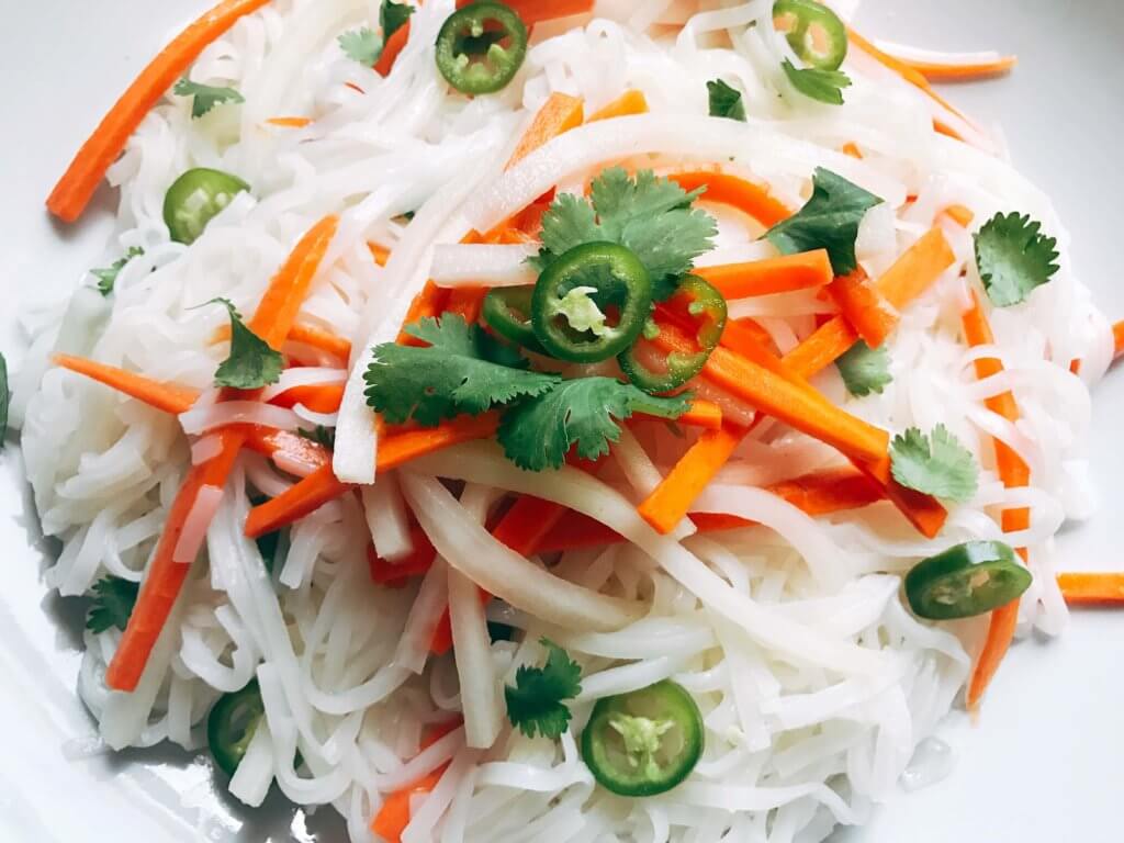 A simple and fast gluten free side dish that is perfect for summer grilling and entertaining. Vegan and vegetarian, this noodle salad is easy to make and a great fresh addition to a BBQ or party like the 4th of July or Father's Day. Add some tofu, chicken, or shrimp for a full dinner meal. Pickled carrots and daikon radish in a rice vinegar bright a fresh brightness and acidity. Make it spicy with some serrano or jalapeno. Vietnamese Pickled Vegetable Rice Noodle Salad | Three Olives Branch | www.threeolivesbranch.com