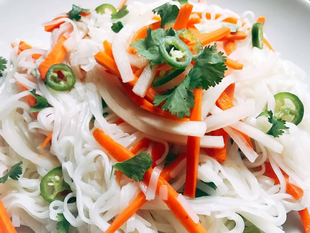 A simple and fast gluten free side dish that is perfect for summer grilling and entertaining. Vegan and vegetarian, this noodle salad is easy to make and a great fresh addition to a BBQ or party like the 4th of July or Father's Day. Add some tofu, chicken, or shrimp for a full dinner meal. Pickled carrots and daikon radish in a rice vinegar bright a fresh brightness and acidity. Make it spicy with some serrano or jalapeno. Vietnamese Pickled Vegetable Rice Noodle Salad | Three Olives Branch | www.threeolivesbranch.com