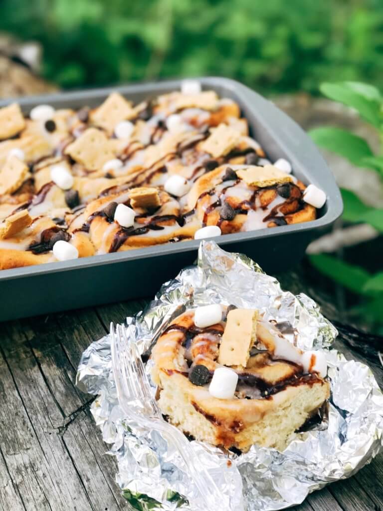 Great for camping and enjoying summer flavors, these rolls are filled with marshmallow fluff, chocolate, and graham crackers. Hold over great for camping trips or cookout parties. Kid friendly and a great way to celebrate summer whether a holiday like 4th of July or a BBQ cookout. S'mores Cinnamon Rolls | Three Olives Branch | www.threeolivesbranch.com