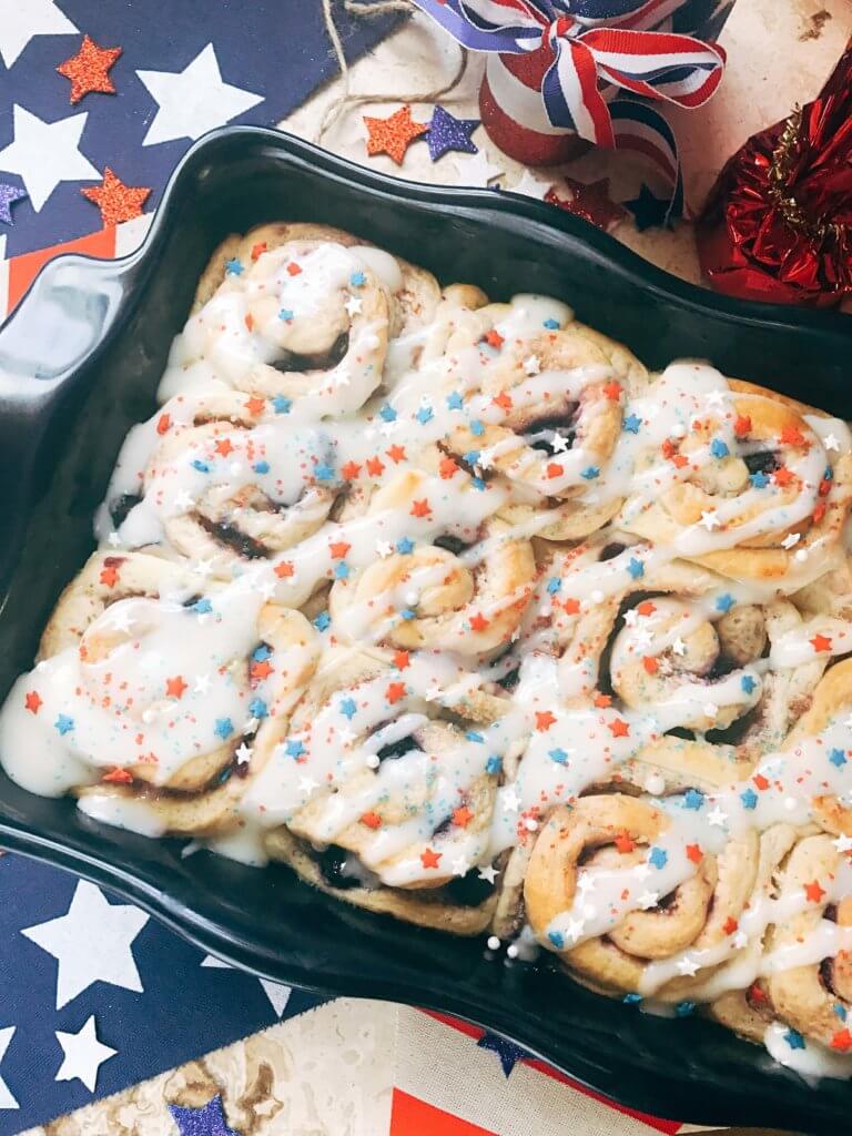 Red, white, and blue sweet rolls for a patriotic morning! A twist on cinnamon rolls, these are filled with cream cheese and mixed berries for a summer treat. Great for patriotic parties and BBQs like Labor Day, Memorial Day, and 4th of July. Make them in advance for a quick and easy breakfast or brunch to start the holiday. They even work as a dessert! Vegetarian and kid friendly. Patriotic Berry Sweet Rolls | Three Olives Branch | www.threeolivesbranch.om