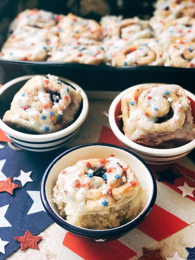 Red, white, and blue sweet rolls for a patriotic morning! A twist on cinnamon rolls, these are filled with cream cheese and mixed berries for a summer treat. Great for patriotic parties and BBQs like Labor Day, Memorial Day, and 4th of July. Make them in advance for a quick and easy breakfast or brunch to start the holiday. They even work as a dessert! Vegetarian and kid friendly. Patriotic Berry Sweet Rolls | Three Olives Branch | www.threeolivesbranch.om