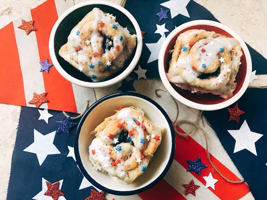 Red, white, and blue sweet rolls for a patriotic morning! A twist on cinnamon rolls, these are filled with cream cheese and mixed berries for a summer treat. Great for patriotic parties and BBQs like Labor Day, Memorial Day, and 4th of July. Make them in advance for a quick and easy breakfast or brunch to start the holiday. They even work as a dessert! Vegetarian and kid friendly. Patriotic Berry Sweet Rolls | Three Olives Branch | www.threeolivesbranch.om