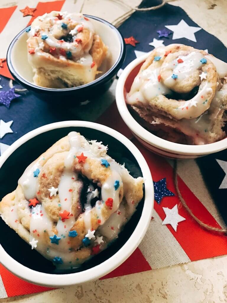 Red, white, and blue sweet rolls for a patriotic morning! A twist on cinnamon rolls, these are filled with cream cheese and mixed berries for a summer treat. Great for patriotic parties and BBQs like Labor Day, Memorial Day, and 4th of July. Make them in advance for a quick and easy breakfast or brunch to start the holiday. They even work as a dessert! Vegetarian and kid friendly. Patriotic Berry Sweet Rolls | Three Olives Branch | www.threeolivesbranch.om
