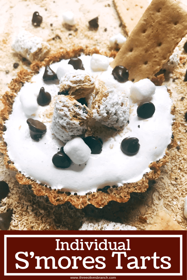 A fun dessert perfect for summer activities like 4th of July and camping. A graham cracker crust is made out of ground Post Shredded Wheat Frosted S'mores Bites Cereal, then filled with melted chocolate, marshmallow fluff, and topped off with some decorations. A fun sweet treat in an individual tart. Individual S'mores Tarts #smores #summerrecipes #campingrecipes