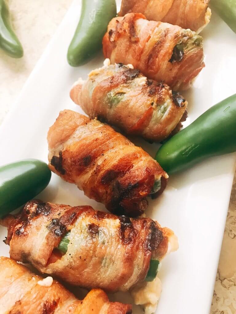 Grill up some of these smoky, cheesy treats for your next summer party. Eckrich Cheddar and Jalapeno Smoked Sausage is stuffed with a jalapeno pepper (which has been filled with cheddar and cream cheese), then rolled in bacon and grilled until crispy. They make such a fun appetizer or dinner for the pork lovers. A fun twist on a jalapeno popper and full of flavor. A great way to kick of football Sunday or game day. Cheddar Jalapeno Smoked Sausage Bacon Bombs | Three Olives Branch | www.threeolivesbranch.com