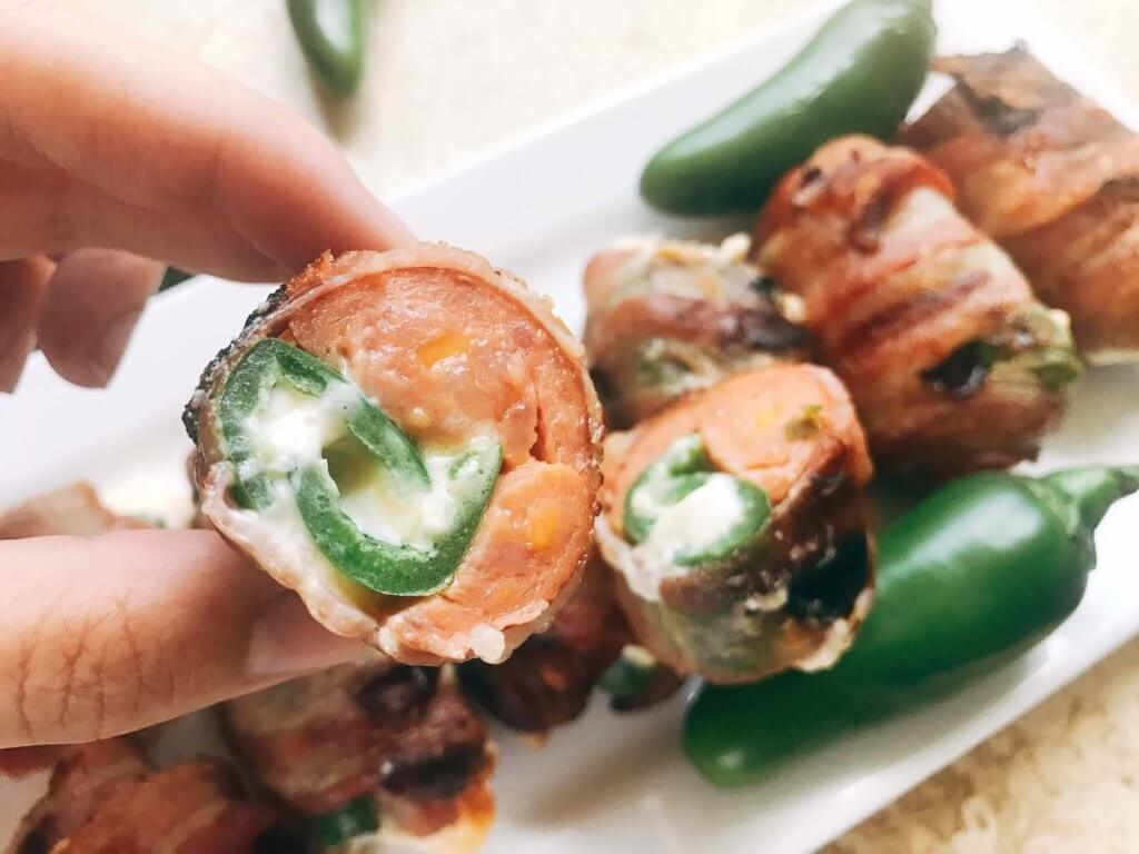 Grill up some of these smoky, cheesy treats for your next summer party. Eckrich Cheddar and Jalapeno Smoked Sausage is stuffed with a jalapeno pepper (which has been filled with cheddar and cream cheese), then rolled in bacon and grilled until crispy. They make such a fun appetizer or dinner for the pork lovers. A fun twist on a jalapeno popper and full of flavor. A great way to kick of football Sunday or game day. Cheddar Jalapeno Smoked Sausage Bacon Bombs | Three Olives Branch | www.threeolivesbranch.com