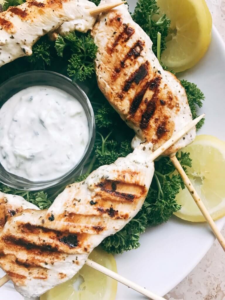 A quick and simple grilled chicken for summer and game day. Chicken is marinated in a mixture of Greek yogurt, lemon, and oregano and grilled. Great on salads, in gyros, wraps, as a main course, and more! Easy and fast to make, a fresh. simple, and light meal. Oregano Lemon Yogurt Greek Chicken Skewers | Three Olives Branch | www.threeolivesbranch.com