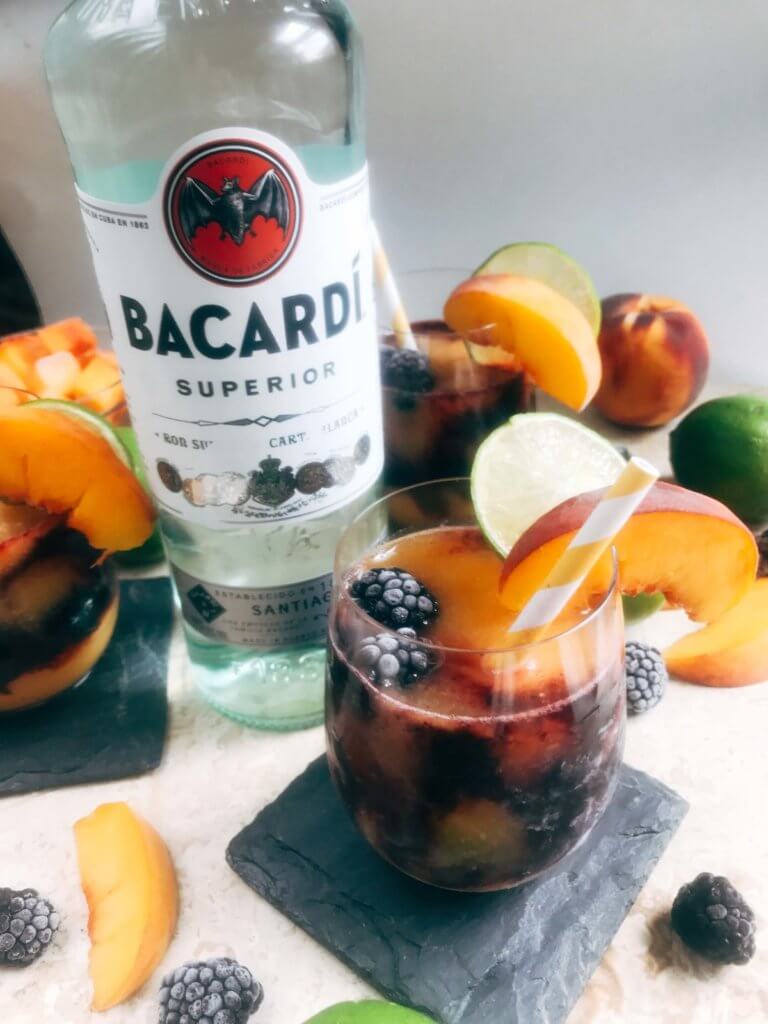 A quick and simple blended alcoholic beverage perfect for warm summer weather. Peaches and blackberries are blended with Bacardi Superior Rum, simple syrup, and lime to make this frozen layered drink. Just 10 minutes for this easy cocktail. Vegan, vegetarian. Blackberry Peach Frozen Daiquiri | Three Olives Branch | www.threeolivesbranch.com