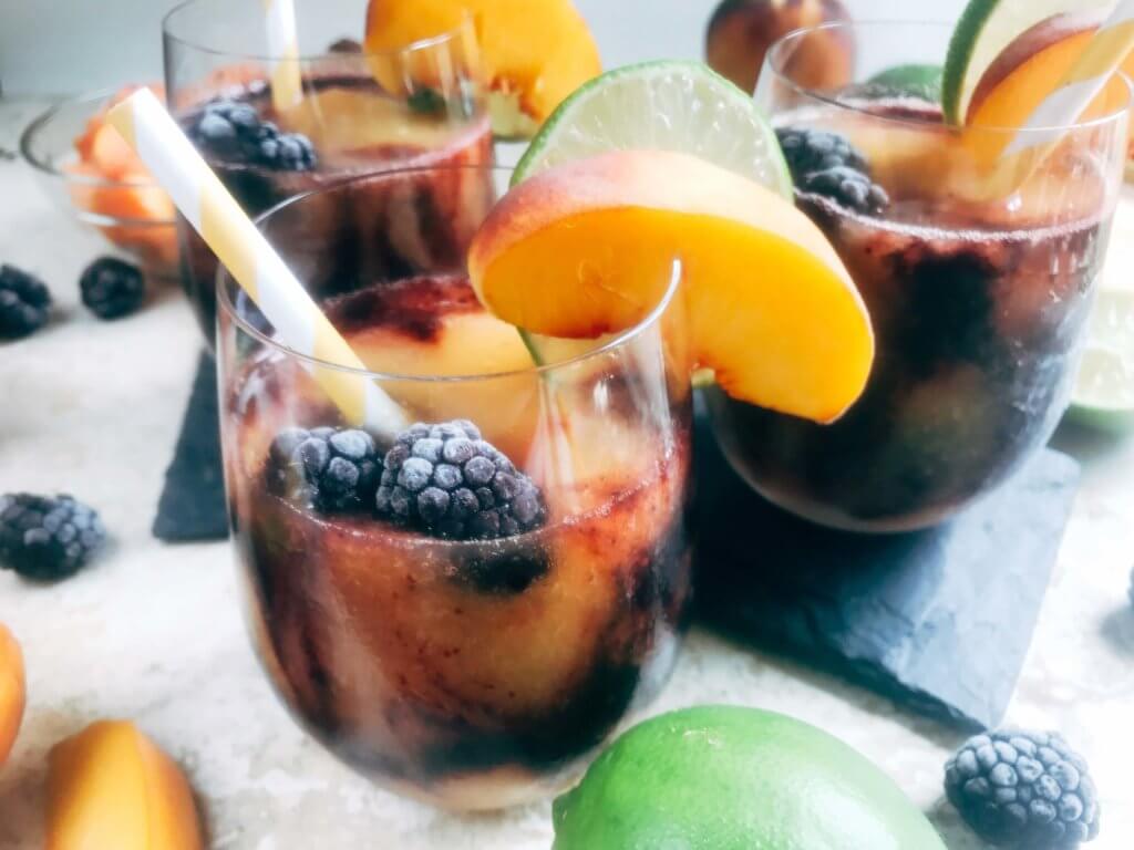 A quick and simple blended alcoholic beverage perfect for warm summer weather. Peaches and blackberries are blended with Bacardi Superior Rum, simple syrup, and lime to make this frozen layered drink. Just 10 minutes for this easy cocktail. Vegan, vegetarian. Blackberry Peach Frozen Daiquiri | Three Olives Branch | www.threeolivesbranch.com