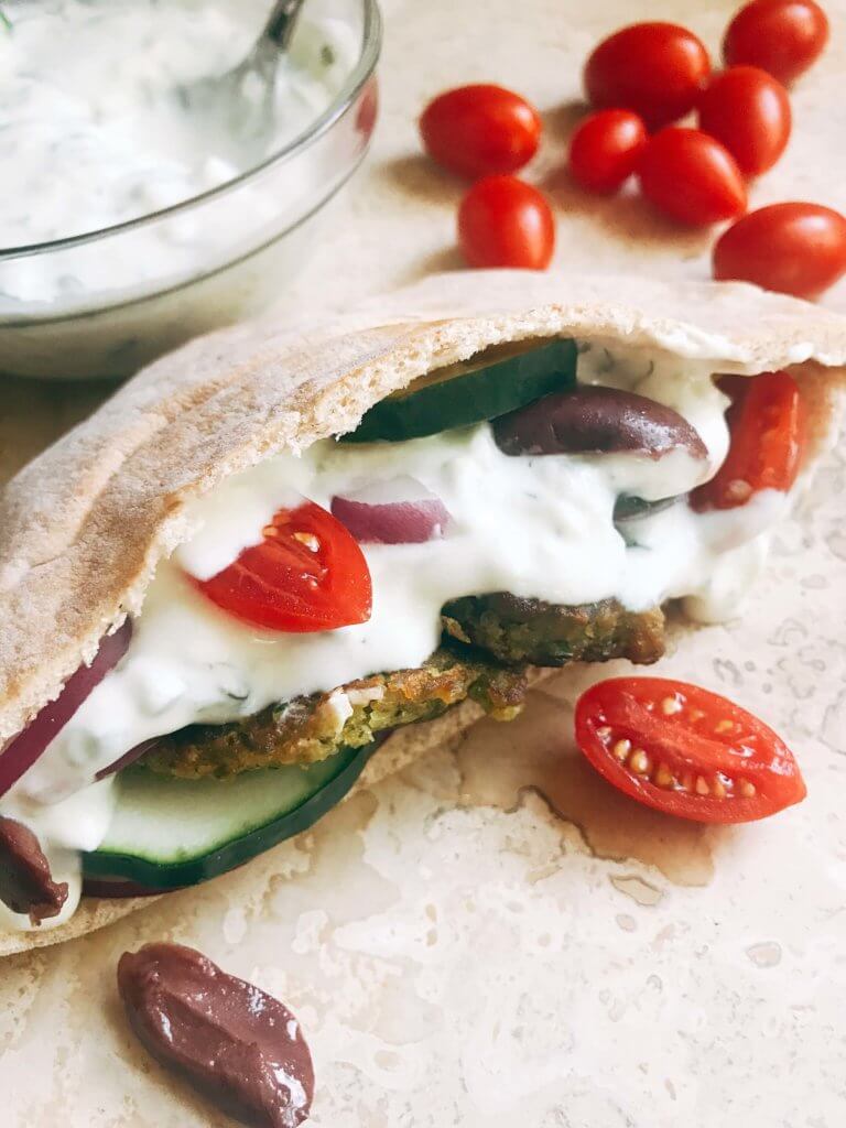 A pita bread filled with falafel, vegetables, and Greek Tzatziki Yogurt Sauce