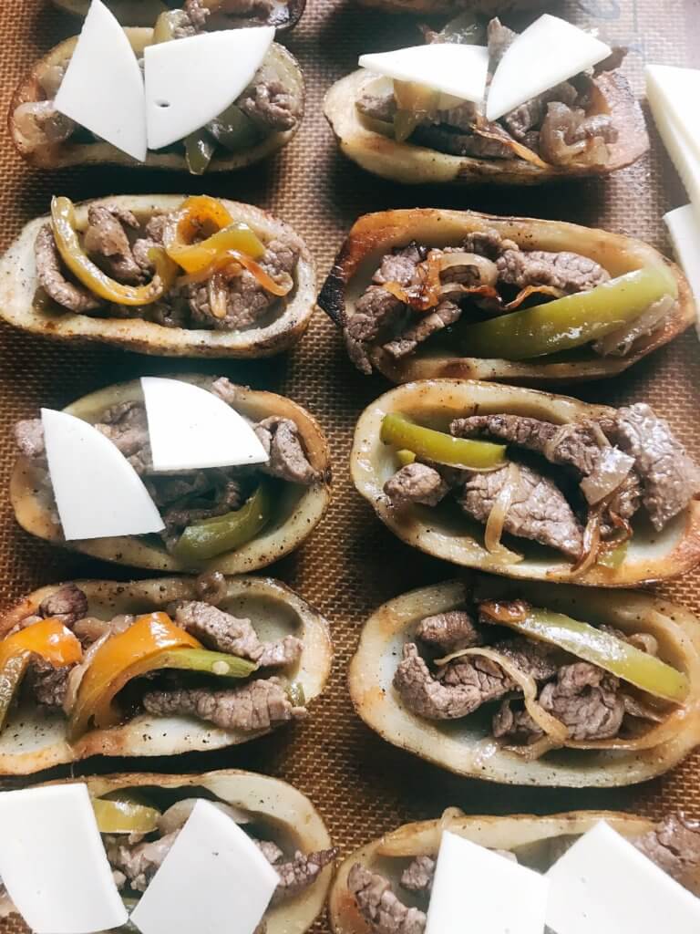 Game day appetizer full of classic Philly Cheese Steak flavors. Beef steak, bell peppers, onion, and provolone cheese in a potato skin shell. Great football food for NFL Sunday as a party snack. Gluten free. Philly Cheesesteak Potato Skins | Three Olives Branch | www.threeolivesbranch.com