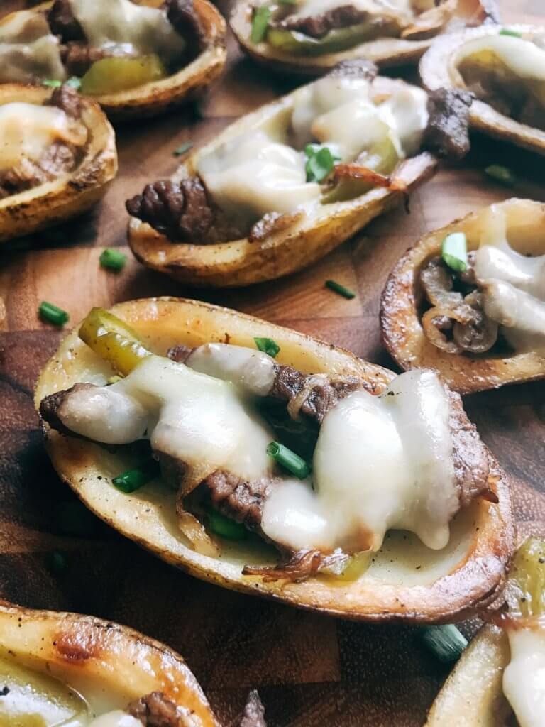 Game day appetizer full of classic Philly Cheese Steak flavors. Beef steak, bell peppers, onion, and provolone cheese in a potato skin shell. Great football food for NFL Sunday as a party snack. Gluten free. Philly Cheesesteak Potato Skins | Three Olives Branch | www.threeolivesbranch.com